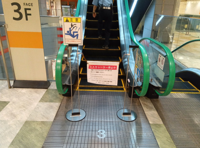 �܂��~�܂��Ă���G�X�J���[�^�[��O�̗��ĎD